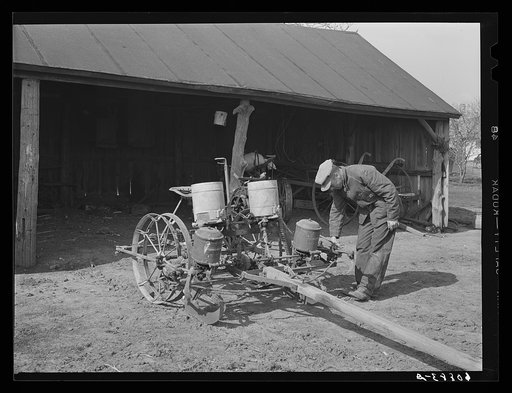 Checking the planter before beginning corn planting operations. Jasper County, Iowa