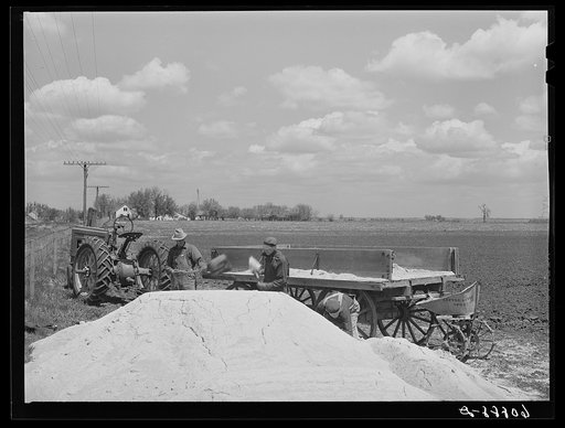 Loading wagon with lime to spread as fertilizer. Jasper County, Iowa