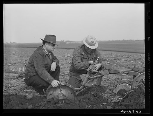County agent watching farmer adjust plow points. Jasper County, Iowa