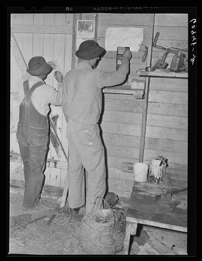 Farmers putting in time slips at end of day. Deshee Unit, Wabash Farms, Indiana. All the land here is farmed cooperatively and profits are distributed according to amount of work done