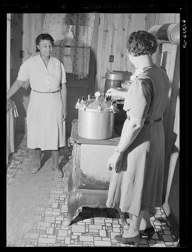 Home supervisor demonstrating use of pressure cooker. Southeast Missouri Farms