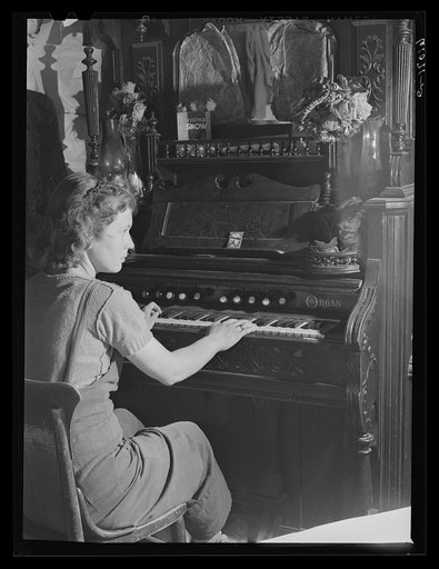 Girl playing organ in shack home on poor land along riverbottoms. Her family will move to one of the Delmo labor homes. New Madrid County, Missouri