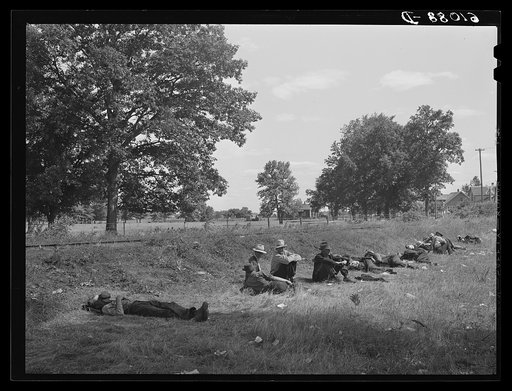 Unemployed fruit tramps sitting along the railroad tracks. Berrien County, Michigan