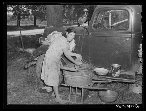 Untitled photo, possibly related to: Mother of migrant fruit picking family doing family wash in roadside camp where fifteen farmers are living. Berrien County, Michigan