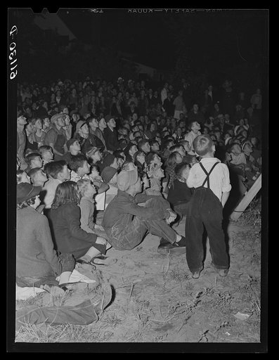 Migrant fruit workers come to town on Saturday night for a free open air movie sponsored by the local merchants who remain open for business. Millburg, Michigan