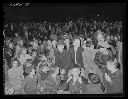 Migratory fruit workers come to town on Saturday night for a free open air movie sponsored by the local merchants who remain open for business.  Millburg, Michigan