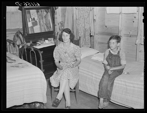 This woman works in the packing plant. Her son works picking fruit with his father. Cabin owned by packing plant rents for one dollar and seventy-five cents a week. Berrien County, Michigan
