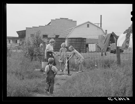 Pump for migrant fruit workers living in nine one-room cabins adjoining packing house. Berrien County, Michigan