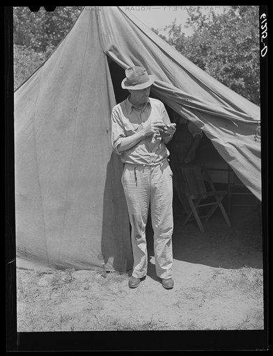 Migrant cherry picker rolling a cigarette. Berrien County, Michigan