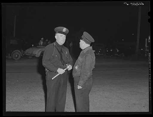 Two policemen on the main street Saturday night when all the migrants come to town. Millburg, Michigan