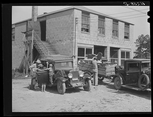 Loading household goods into cars and trailer. Two families getting ready to move on in search of work picking fruit. Berrien County, Michigan
