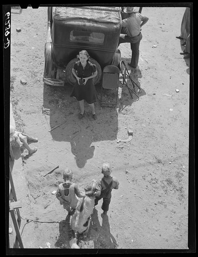 Untitled photo, possibly related to: Loading household goods into cars and trailer. Two families getting ready to move on in search of work picking fruit. Berrien County, Michigan