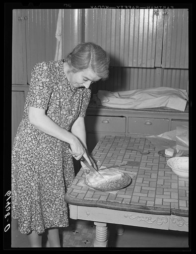 Farm woman cutting pieces of pie for supper. Meeker County, Minnesota