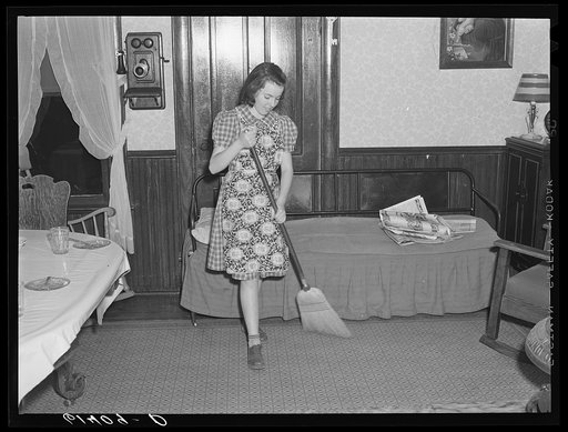 Farm girl sweeping the floor. Meeker County, Minnesota
