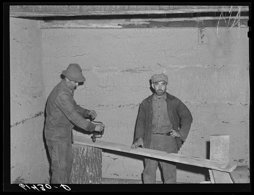 Mr. Irving and son, FSA (Farm Security Administration) borrowers, building a log cabin. The inside walls are plastered with a mixture of mud and straw. Ross County, Ohio