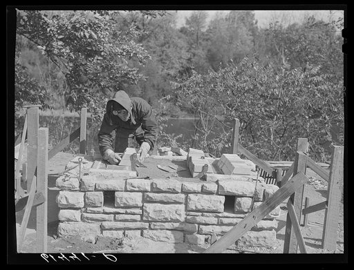 CCC (Civilian Conservation Corps) boy building charcoal burner at picnic grounds of recreation area. Ross County, Ohio