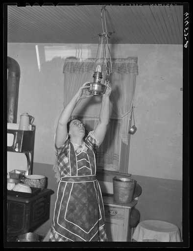 Mrs. Sauer hanging up oil lamp. Cavalier County, North Dakota