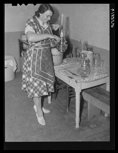 Mrs. Sauer putting oil in lamp. Cavalier County, North Dakota