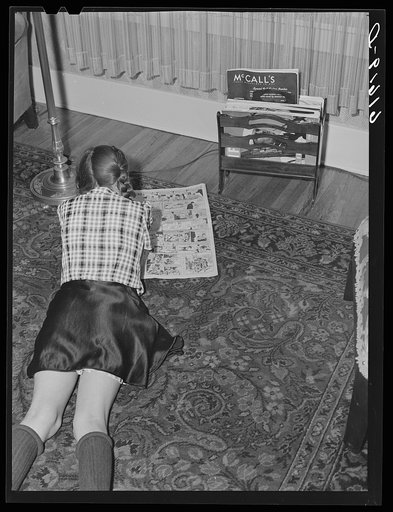 One of the Schulstead children reading funny papers. Aberdeen, South Dakota