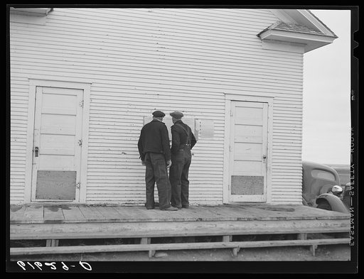 Farmers reading ballots posted outside schoolhouse. Election day, McIntosh County, North Dakota