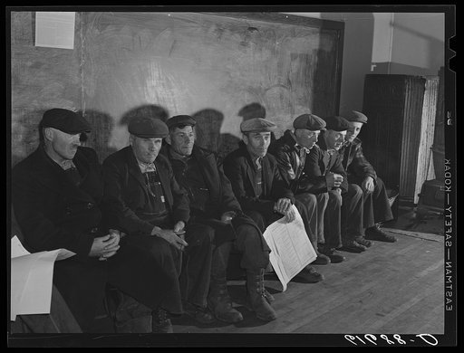 German-Russian farmers waiting to vote in presidential election, November 1940. Beaver Creek precinct, McIntosh County, North Dakota. Men with caps, sitting indoors
