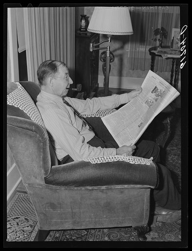 L.M. Schulstad, traveling saleman for hardware company, reading the editorials. Aberdeen, South Dakota