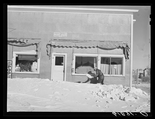Shoveling snow in front of post office. Mission, South Dakota
