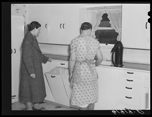 Home supervisor with wife of tenant purchase borrower in new kitchen. Labette County, Kansas