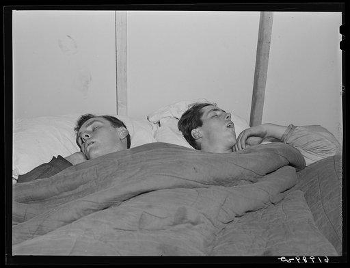 Construction workers sleeping in room in basement of secondhand furniture store. Radford, Virginia