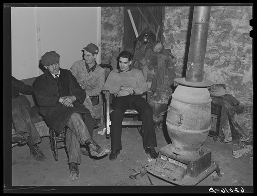 Men sitting around stove in basement of Mr. Tilly's store. He lets them sit here all night. Radford, Virginia