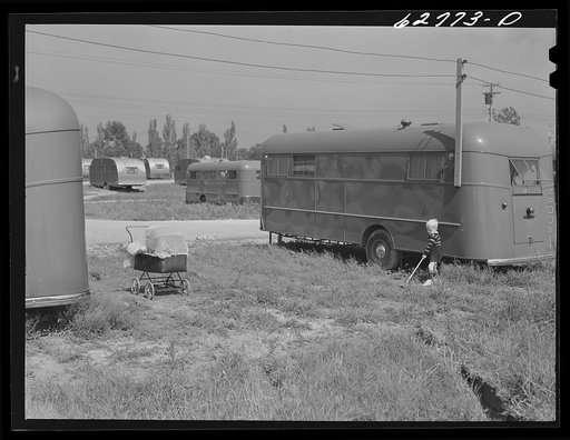 Untitled photo, possibly related to: Maintenance man at FSA (Farm Security Administration) camp, Erie, Pennsylvania, talking with little boy who lives in trailer. General Electric plant in background