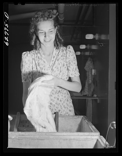 Wife of defense worker washing clothes in utility building at FSA (Farm Security Administration) trailer camp. Erie, Pennsylvania