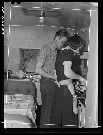Mr. and Mrs. Jack Cutter preparing noonday meal in kitchen of their trailer home. FSA (Farm Security Administration) camp, Erie, Pennsylvania