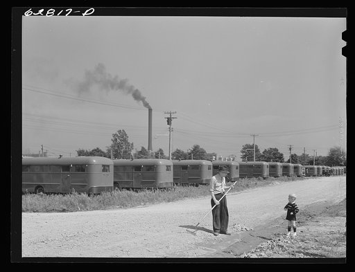 Maintenance man at FSA (Farm Security Administration) camp, Erie, Pennsylvania, talking with little boy who lives in trailer. General Electric plant in background