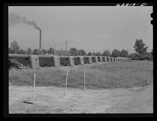 Untitled photo, possibly related to: Maintenance man at FSA (Farm Security Administration) camp, Erie, Pennsylvania, talking with little boy who lives in trailer. General Electric plant in background
