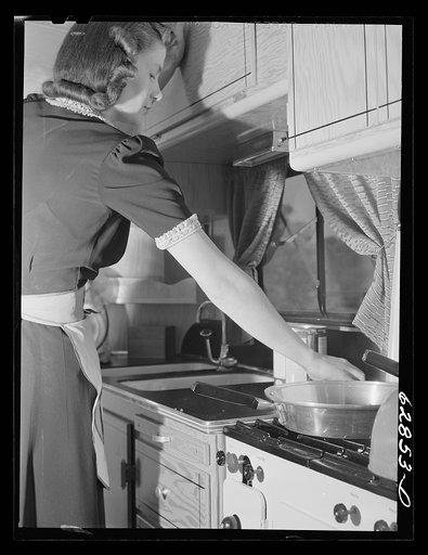 Untitled photo, possibly related to: Mr. and Mrs. Jack Cutter preparing noonday meal in kitchen of their trailer home. FSA (Farm Security Administration) camp, Erie, Pennsylvania