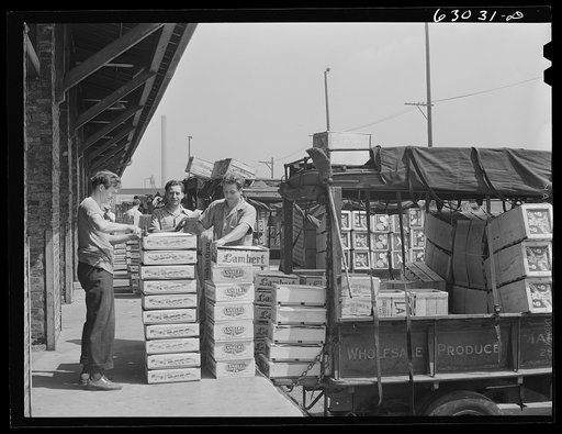 Loading crates of fruits into truck at fruit terminal. Chicago, Illinois