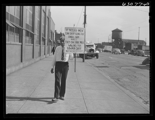 Untitled photo, possibly realted to: Negro carrying sign in front of milk company. Chicago, Illinois