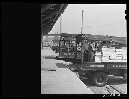 Untitled photo, possibly related to: Loading crates of fruits into truck at fruit terminal. Chicago, Illinois