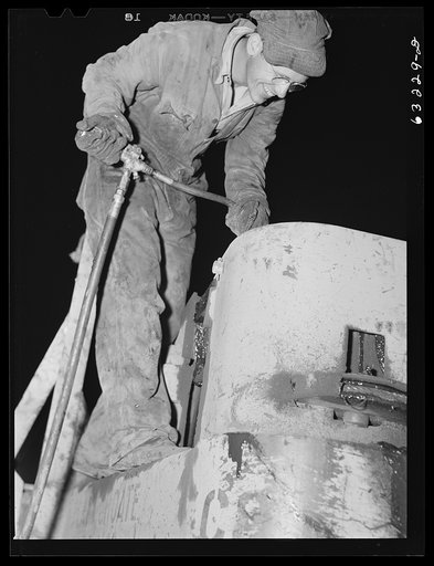 Untitled photo, possibly related to: Member of road construction gang greasing "cats" at night. Grant County, Wisconsin