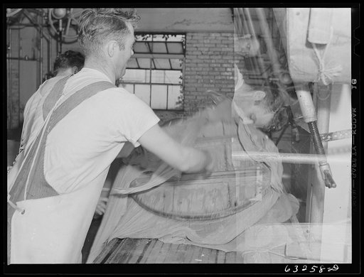 Untitled photo, possibly related to: Pressing the curd into form. Swiss cheese factory. Madison, Wisconsin