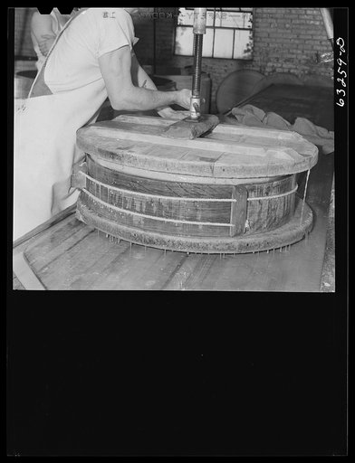 Untitled photo, possibly related to: Pressing the curd into form. Swiss cheese factory. Madison, Wisconsin
