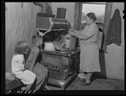 Wife of FSA (Farm Security Administration) borrower removing canned cherries from pressure cooker. Itasca County, Minnesota, cut-over area