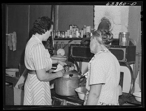 Home supervisor showing FSA (Farm Security Administration) borrower how to use pressure cooker. Mille Lacs County, Minnesota