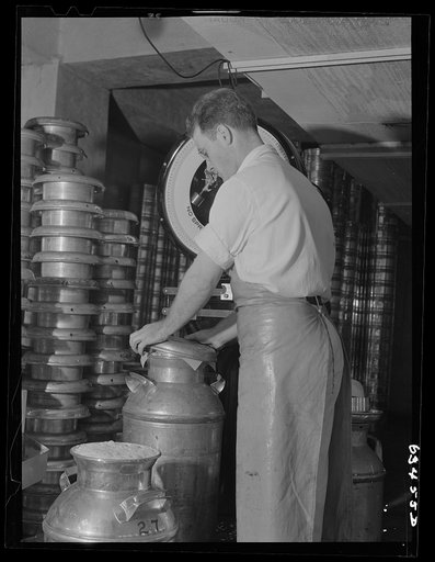 Clamping cover on cans of cream. Antigo, Wisconsin