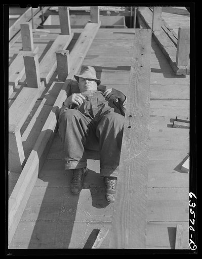 Crew member resting while Great Lakes boat "James Watt" is being loaded with wheat to go to Buffalo flour mills. Elevator "E". Duluth, Minnesota