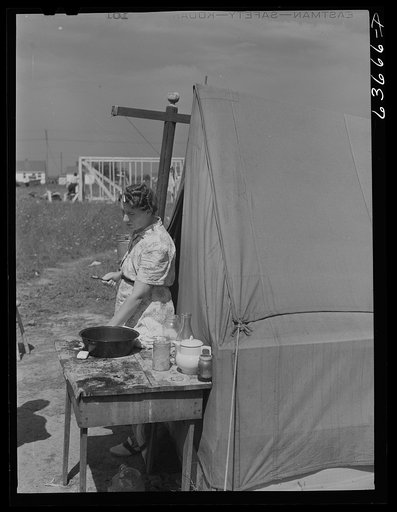 Mother and family living in tent beside foundation of house which her husband, a defense worker, is building for himself. Detroit, Michigan