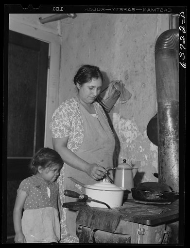 Wife and child of Mexican sugar beet worker in community kitchen, in one of the houses at Saginaw Farms, a FSA (Farm Security Administration) project