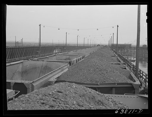 Cars of iron ore on dock. They will be dumped into bins under the docks which hold about six carfuls. There are over 1200 bins. Allouez, Wisconsin
