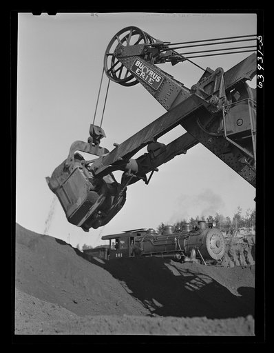 Electric shovel loading iron ore into railroad cars, eight cubic yards per shovelful. Mahoning Mine. Hibbing, Minnesota
